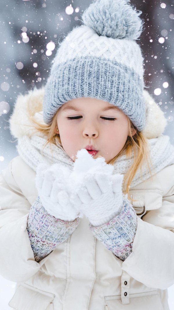 девочка дует на снег