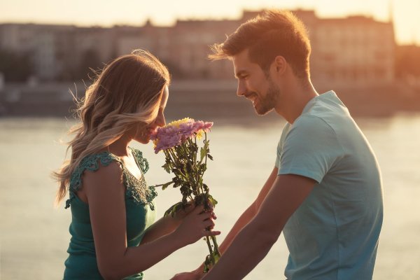 парень дарит девушке цветы