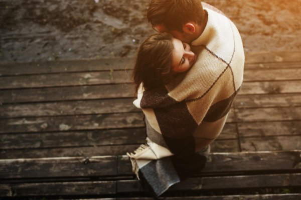 мужчина укрывает женщину пледом