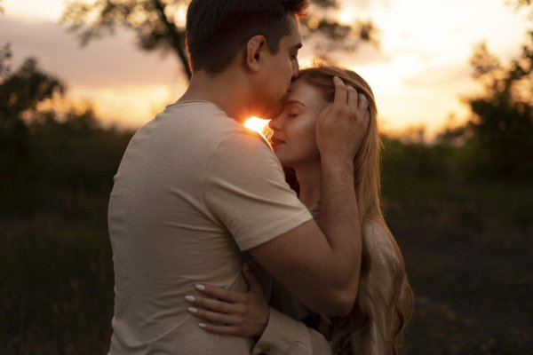 мужчина целует женщину в лоб