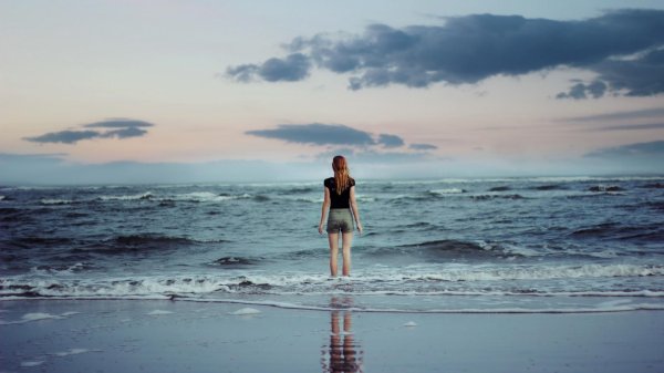 Девушка на берегу моря спиной