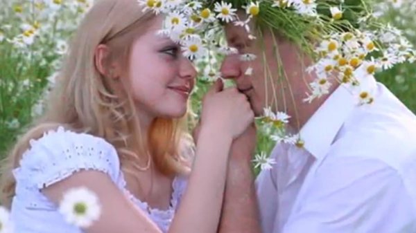 мужчина дарит женщине ромашки