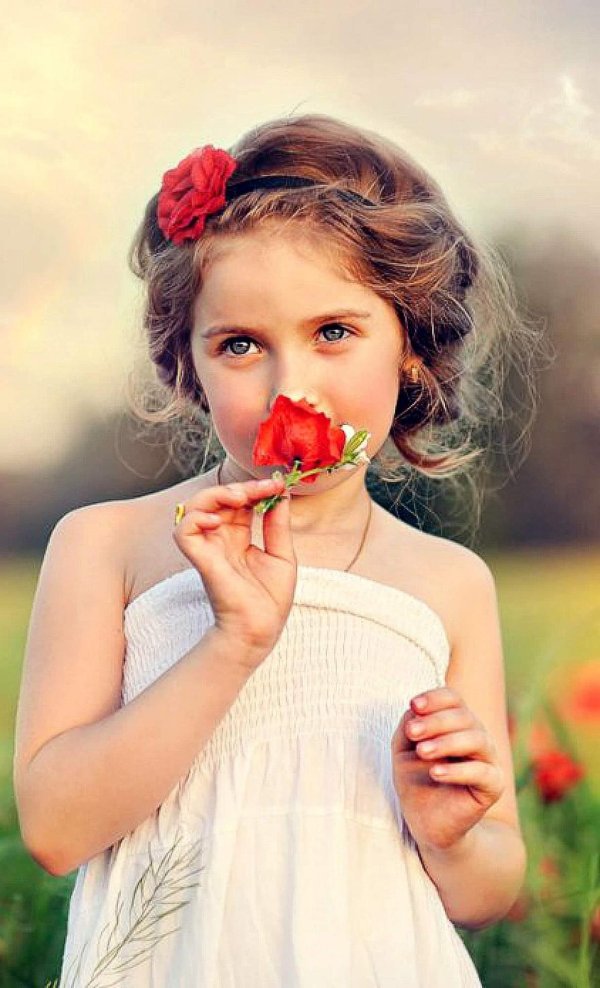 девочка нюхает цветок