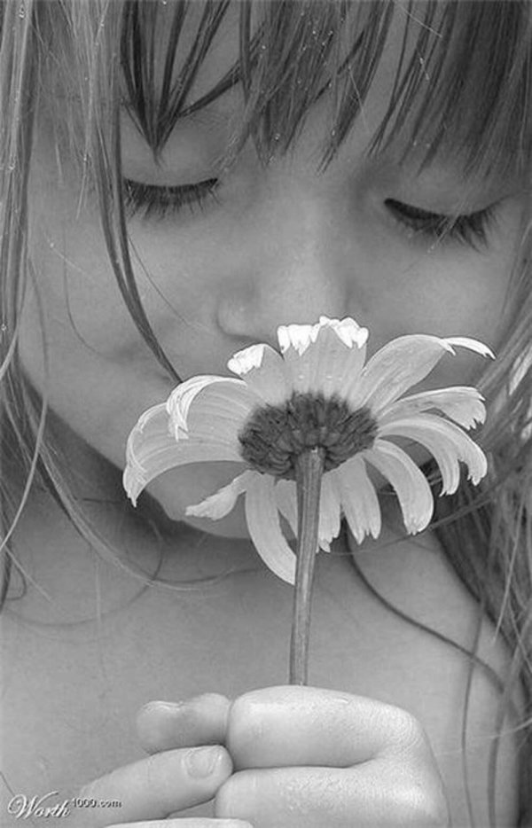 маленькая девочка нюхает цветы